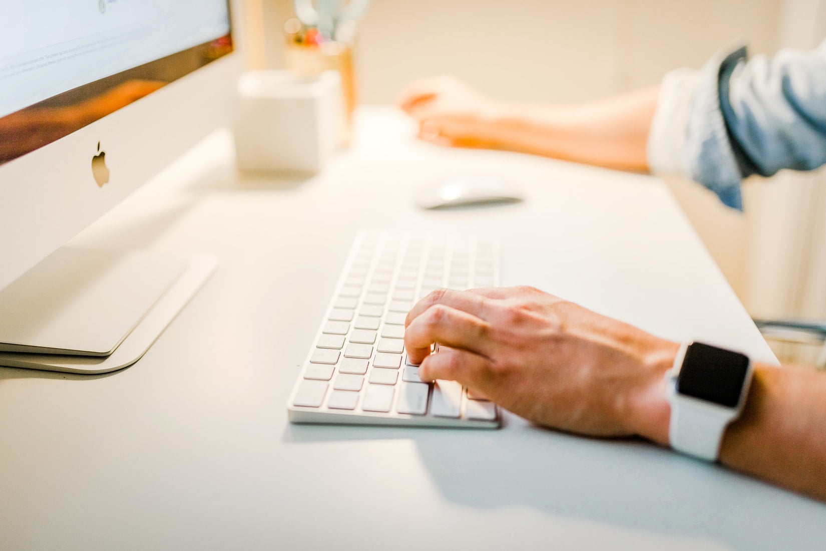 Man typing on white desk