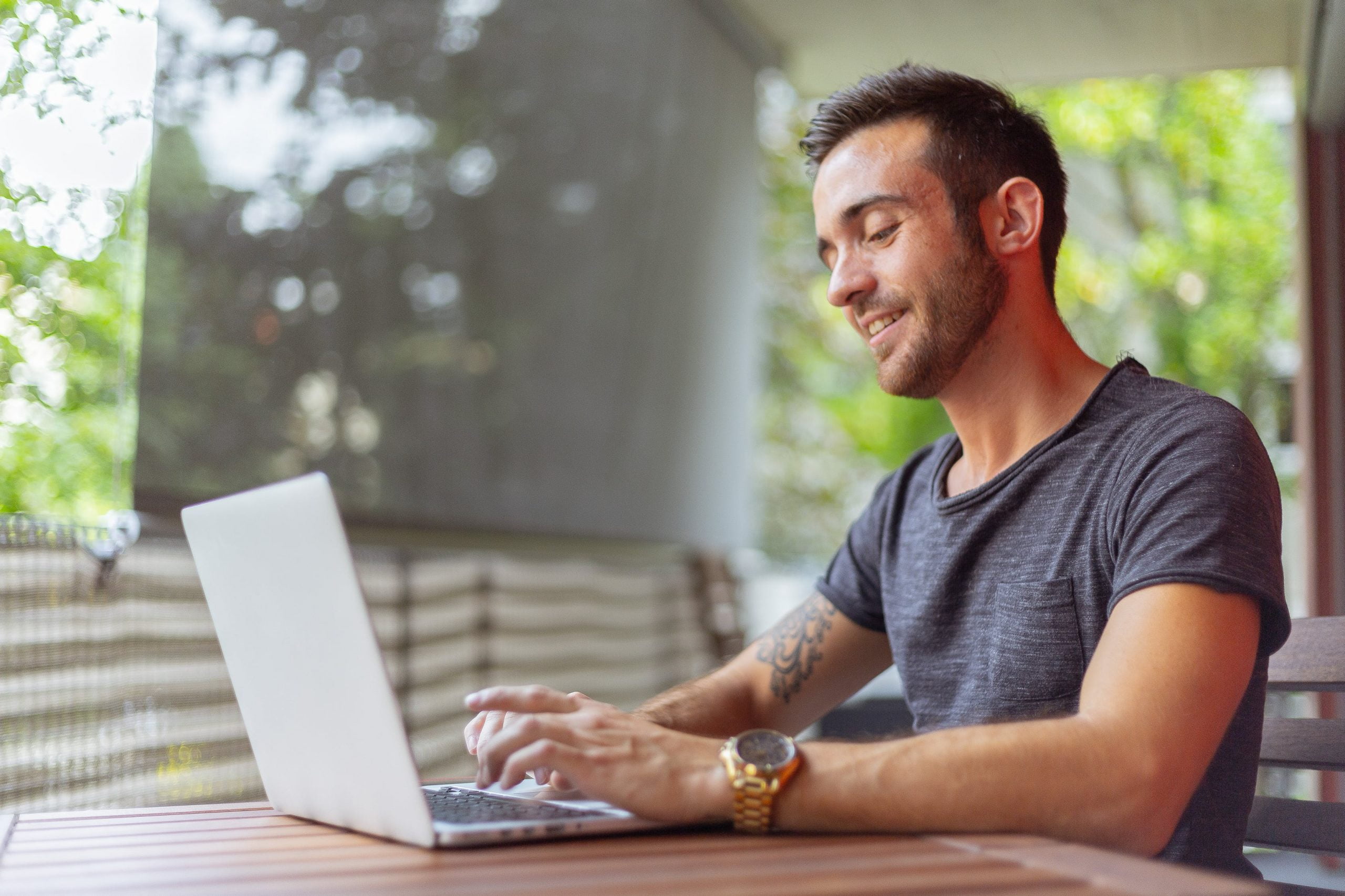 Man typing on laptop while smiling