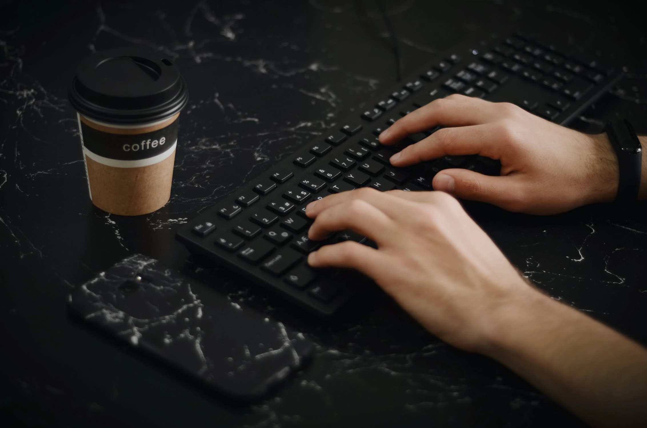 Person typing on black keyboard