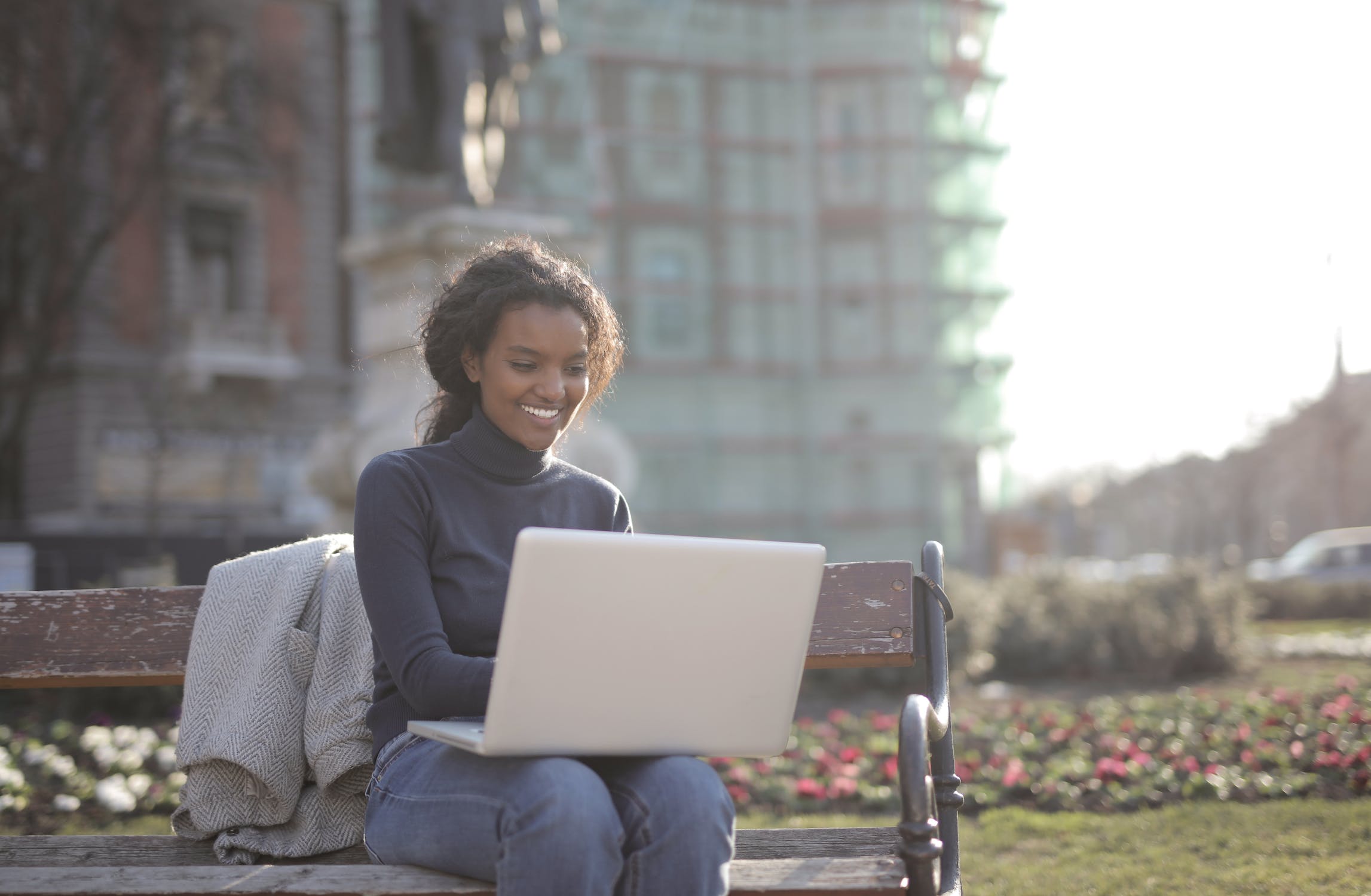 Woman typing while sitting on bench