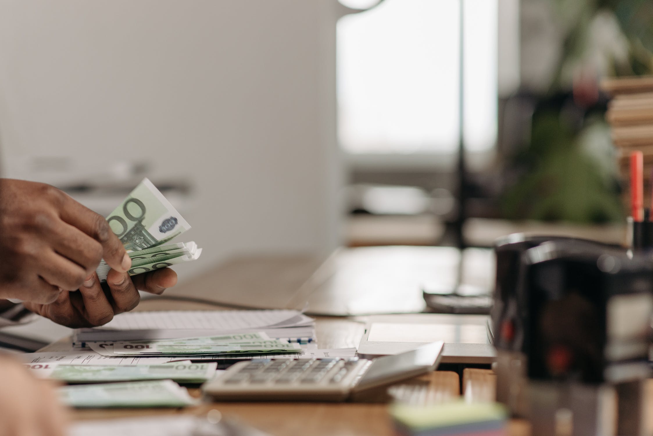 Person counting money on desk